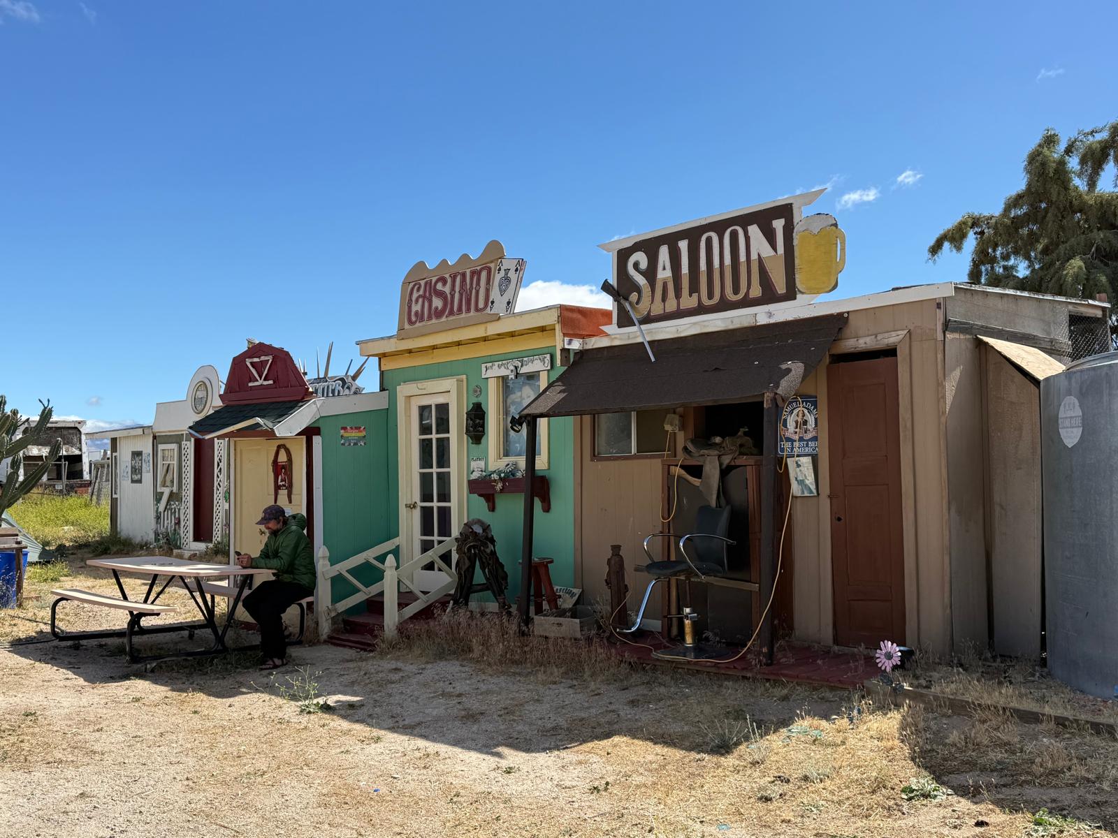 A crew member resting at a picnic table outside the saloon set